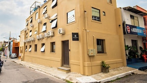 A multi-story building with air conditioning units, a visible entrance, and a street view. - Amazinn Hotel (Belém)
