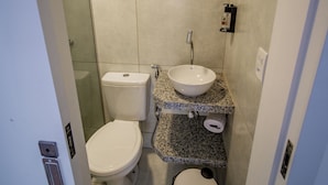 A compact bathroom with a toilet, sink, and trash bin. - Amazinn Hotel (Belém)