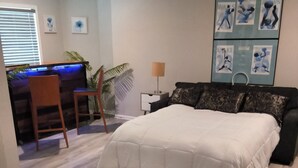 A bedroom with a bed, a desk with a chair, a plant, and artwork on the wall. - Private Studio near Atlanta ,20 min to Mercedes-Benz Stadium, Separate Entrance (Lithia Springs)