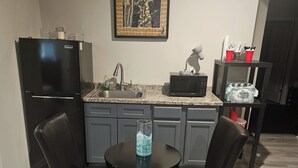 A kitchen with a refrigerator, microwave, and sink. There is a dining table with chairs and a painting on the wall. - Private Studio near Atlanta ,20 min to Mercedes-Benz Stadium, Separate Entrance (Lithia Springs)