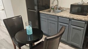 A kitchen with a dining table, chairs, a refrigerator, a microwave, and a sink. - Private Studio near Atlanta ,20 min to Mercedes-Benz Stadium, Separate Entrance (Lithia Springs)