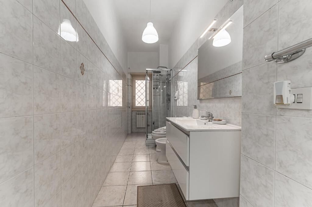 A modern bathroom with a shower, toilet, and sink.