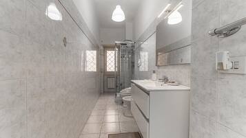A modern bathroom with a shower, toilet, and sink.