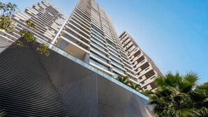 A modern high-rise building with a distinctive angular design, featuring multiple balconies and a glass facade. - Apts in a Condo. w/ Pool, a few Steps fr/ Vaca Brava Park - Obds (Goiânia)
