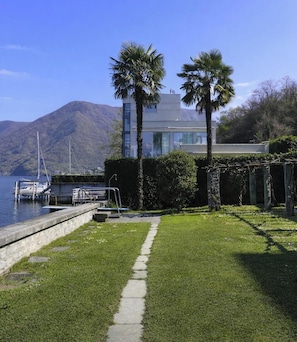 Ein modernes Haus mit Pool, Palmen und einem Berg im Hintergrund.