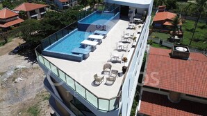 A rooftop pool with lounge chairs and a glass balustrade. - Prime Beach Carneiros (Tamandaré)