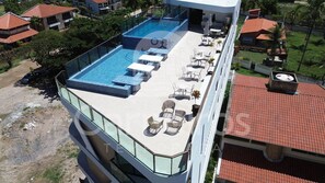 A rooftop pool with lounge chairs and a glass balustrade. - Prime Beach Carneiros (Tamandaré)