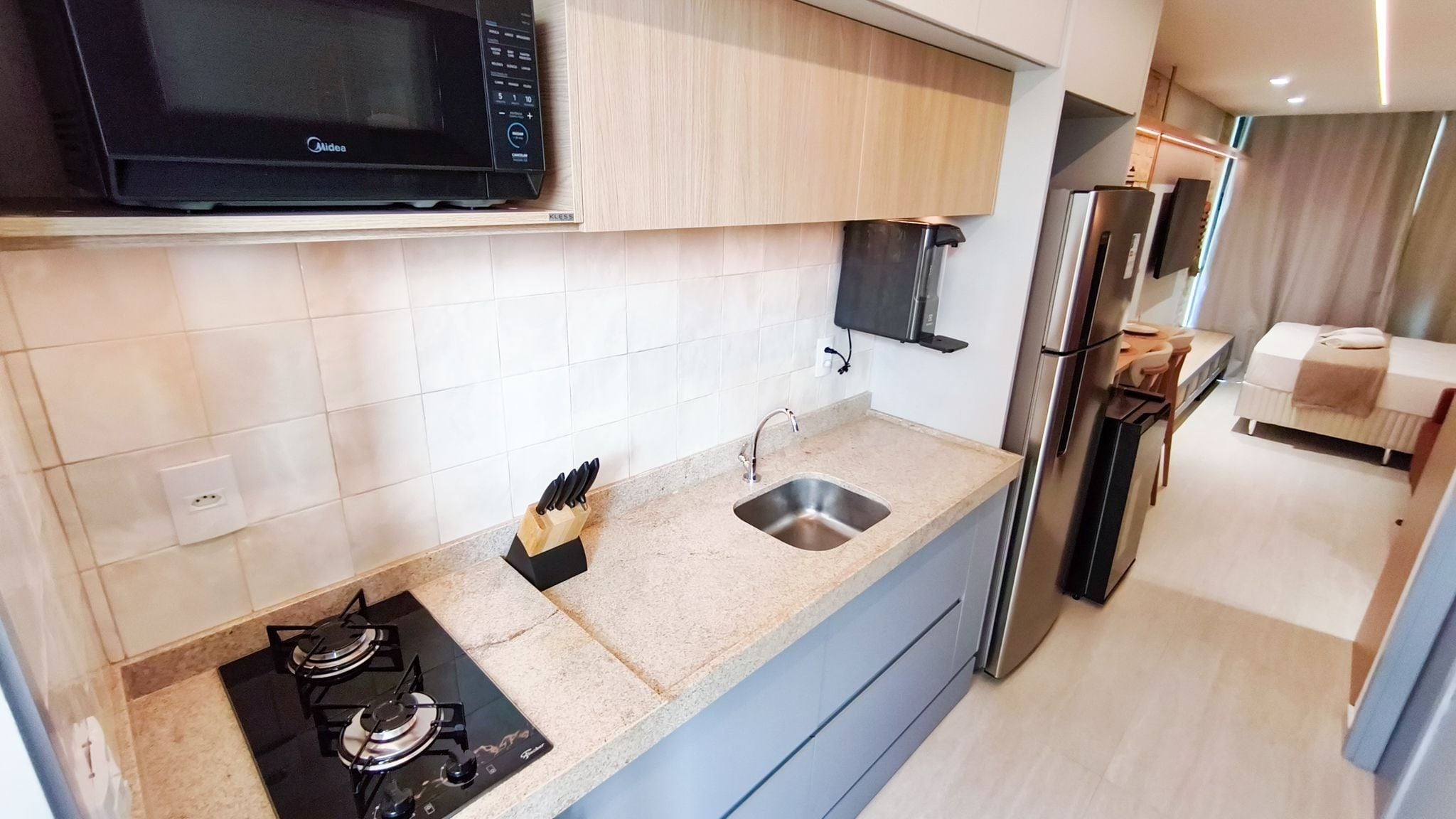 A modern kitchen with a built-in microwave, gas stove, and stainless steel sink.