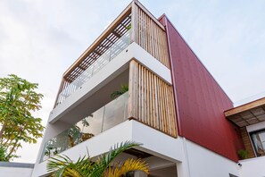 A modern building with a white facade, wooden slats, and a red accent wall. - Flat with sea view (Saint Pierre)