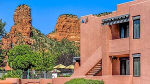 Un edificio con una scala, vista su formazioni rocciose rosse e un cielo azzurro intenso.
