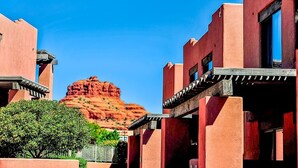 Un edificio con tetto piatto e una grande formazione rocciosa sullo sfondo.