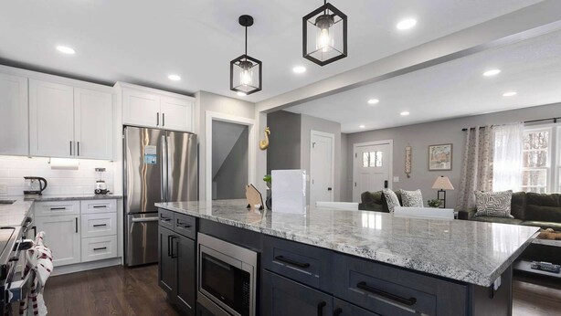 A modern kitchen with stainless steel appliances, a marble countertop, and pendant lighting. - 5 Bedrooms w. TVs in every room & Garage Parking (Overland Park)