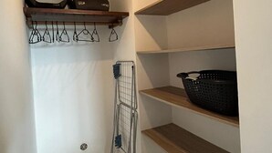 A laundry area with shelves, a drying rack, and a basket. - 2-bedroom apartment with private pool (Saint-Paul)