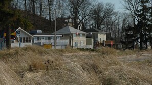 A row of two-story houses with a stop sign and a beach access sign in the foreground.