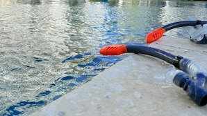 Een zwembad met een waterfiltersysteem, omringd door moderne gebouwen met balkons.