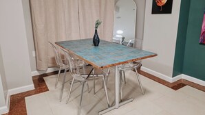 A dining area with a table, chairs, a vase, a mirror, and a wall with a framed picture. - Element / King Bed / Elevator / Adjustable Desk (Philadelphia)
