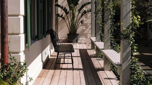 A covered porch with a bench, steps leading up to it, and a potted plant. - Wedged Inn (Dunmore Town)