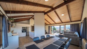 Une pièce spacieuse comprenant une grande table à manger, un canapé et un coin cuisine.