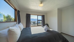Une chambre d’hôtel avec un grand lit, une vue sur l’extérieur et un luminaire au plafond.