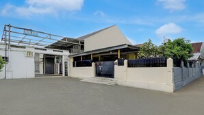 Een gebouw met een bord waarop 'HOME STAY' staat en een hekwerk.