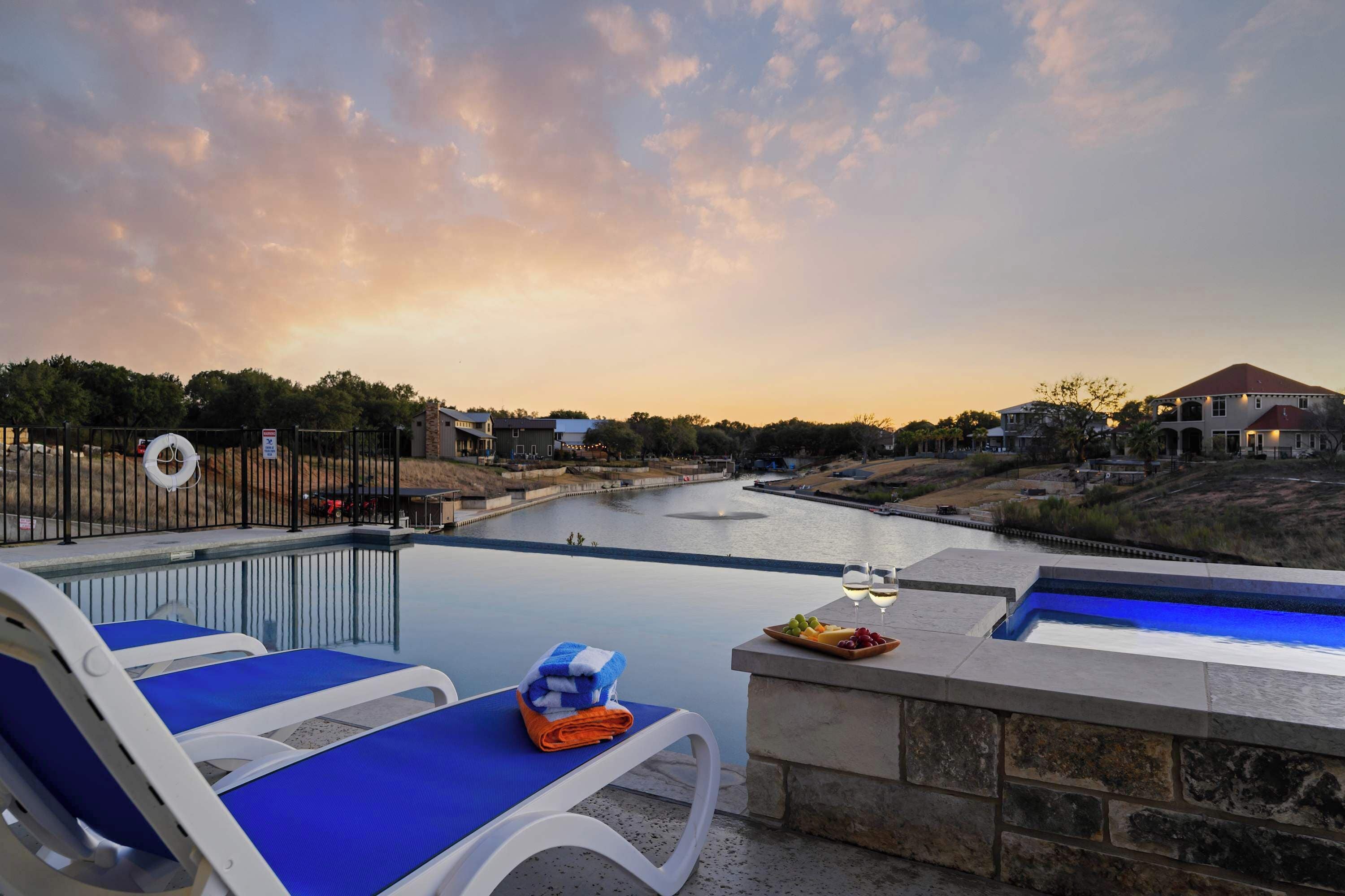 A poolside area with lounge chairs, a stone bench, and a fruit plate.