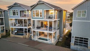 Un immeuble résidentiel à plusieurs étages, doté de balcons, d’une piscine et d’un garage.