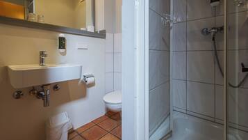 Un baño con lavamanos, inodoro y ducha.