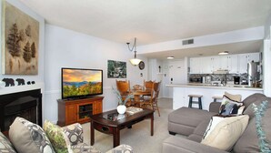 Una sala de estar con chimenea, televisor y zona de estar.