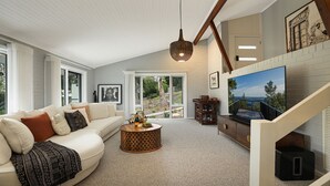 A living room with a sofa, coffee table, and a TV mounted on a wall. - Arcadia Cottage - spacious, stylish Highlands stay for families and groups near Bowral (Bowral)