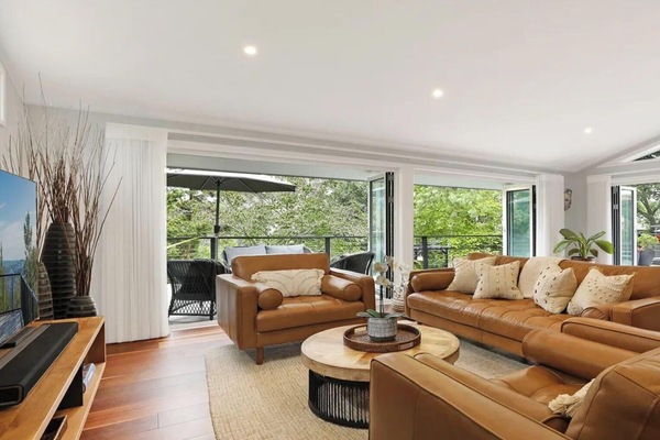 Arcadia Cottage | Living area in open plan room with kitchen and dining area | Back doors open onto beautiful uncovered deck with lounges and alfresco dining | Smart TV with Sonos soundbar | Central ducted heating throughout property