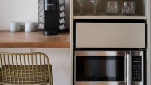 Une petite cuisine équipée d’une machine à café, d’un four à micro-ondes et de verres à vin rangés sur une étagère.