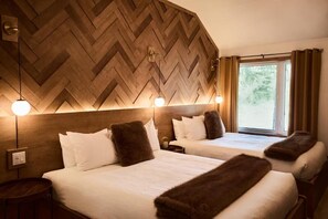 A hotel room with two beds, wooden wall paneling, and a window with curtains. - Motel.Boutique Hygge (Baie-Saint-Paul)