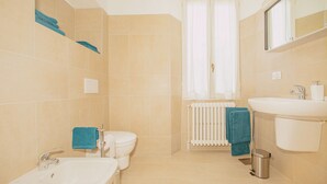 Kylpyhuone, jossa on pesuallas, wc ja patteri.