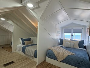 A bedroom with two beds, a window with a view, and a ceiling with a geometric design. - NEW - Private Lakefront Home w/AC - 2 miles from Downtown Caseville (Caseville)