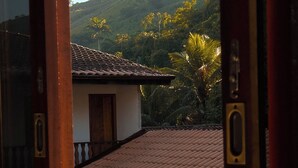 Blick aus dem Fenster auf ein Gebäude mit einem Ziegeldach und einer Tür mit Messingbeschlägen.