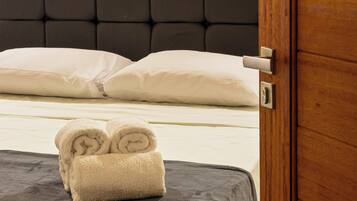Una habitación de hotel con una cama, una puerta de madera y una toalla sobre la cama.