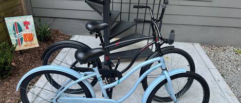 A light blue bicycle with a black seat and handlebars, parked on a concrete surface.