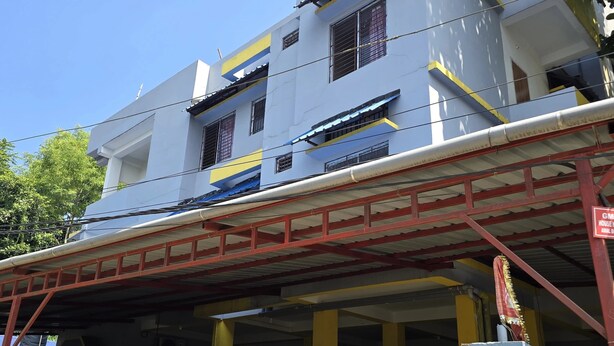A multi-story building with a covered parking area and a gated entrance. - Maa Durga Homestay (Guwahati)