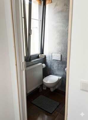 Een douche, handdoeken, zeep, toiletpapier