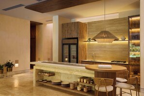 Una cocina moderna con una isla central, electrodomésticos integrados y una pared decorativa de madera.
