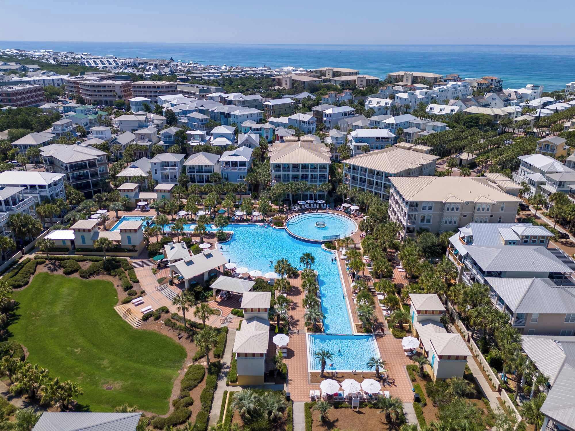 Ein Resort mit einem zentralen Pool, mehreren Gebäuden und Blick auf den Ozean.