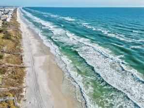 A coastal beach with a sandy shoreline, a wooden boardwalk, and waves approaching the shore. - Splash Pad- Dog Friendly- Seacrest Beach! (Rosemary Beach)