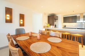 A modern kitchen with dark cabinets, a stainless steel refrigerator, and a built-in oven. - The Pearl Jaco Beach (Jacó)