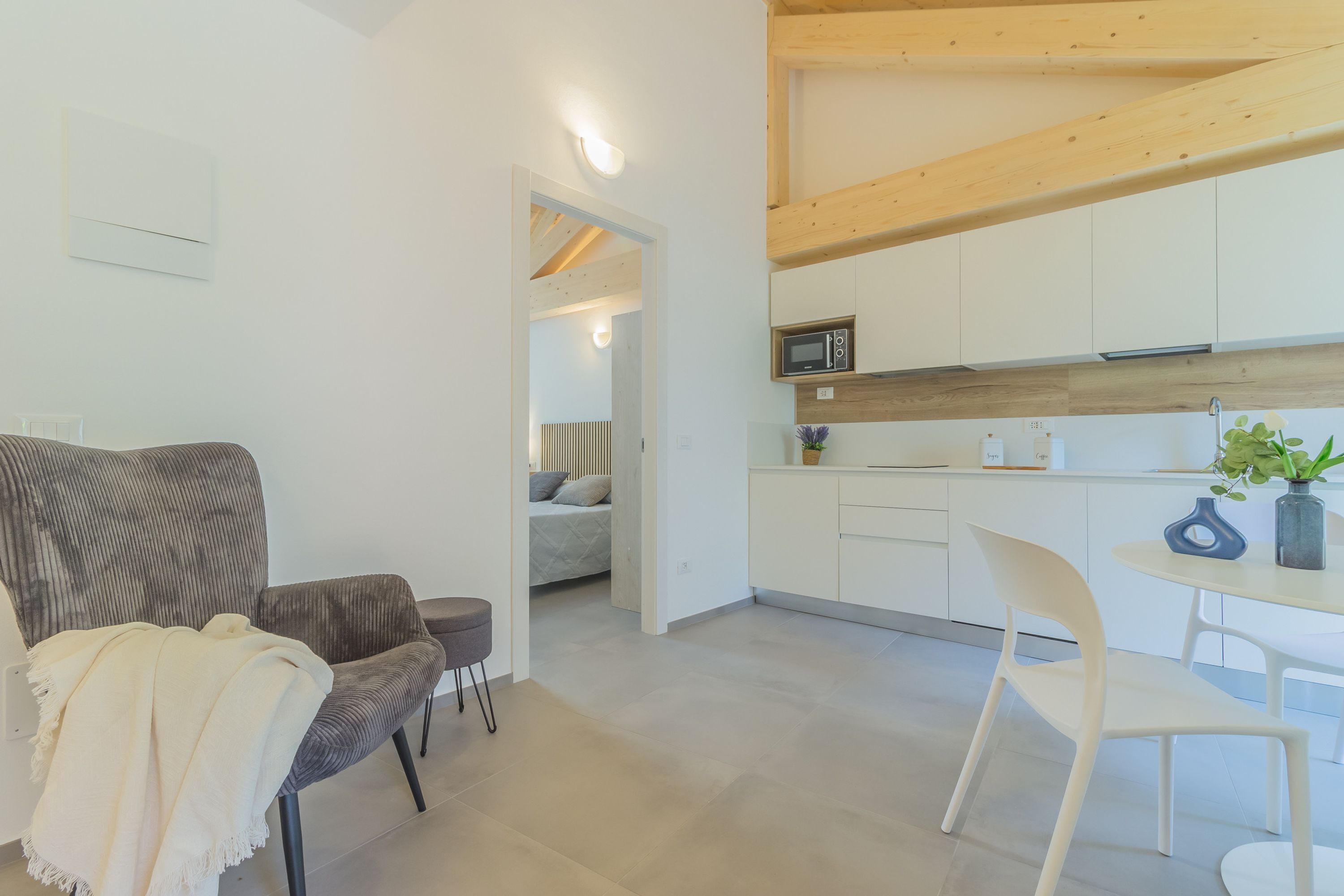 A modern interior with a sofa, dining table, and kitchen area.