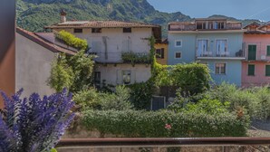 Eine Reihe bunter Gebäude mit Balkonen, umgeben von üppiger Vegetation und Bergen im Hintergrund.