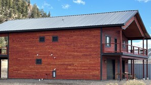 Ein großes Holzgebäude mit Balkon und Metalldach.