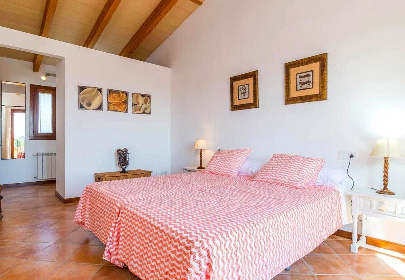 Une chambre à coucher avec un lit, deux tables de chevet, une lampe et un miroir.