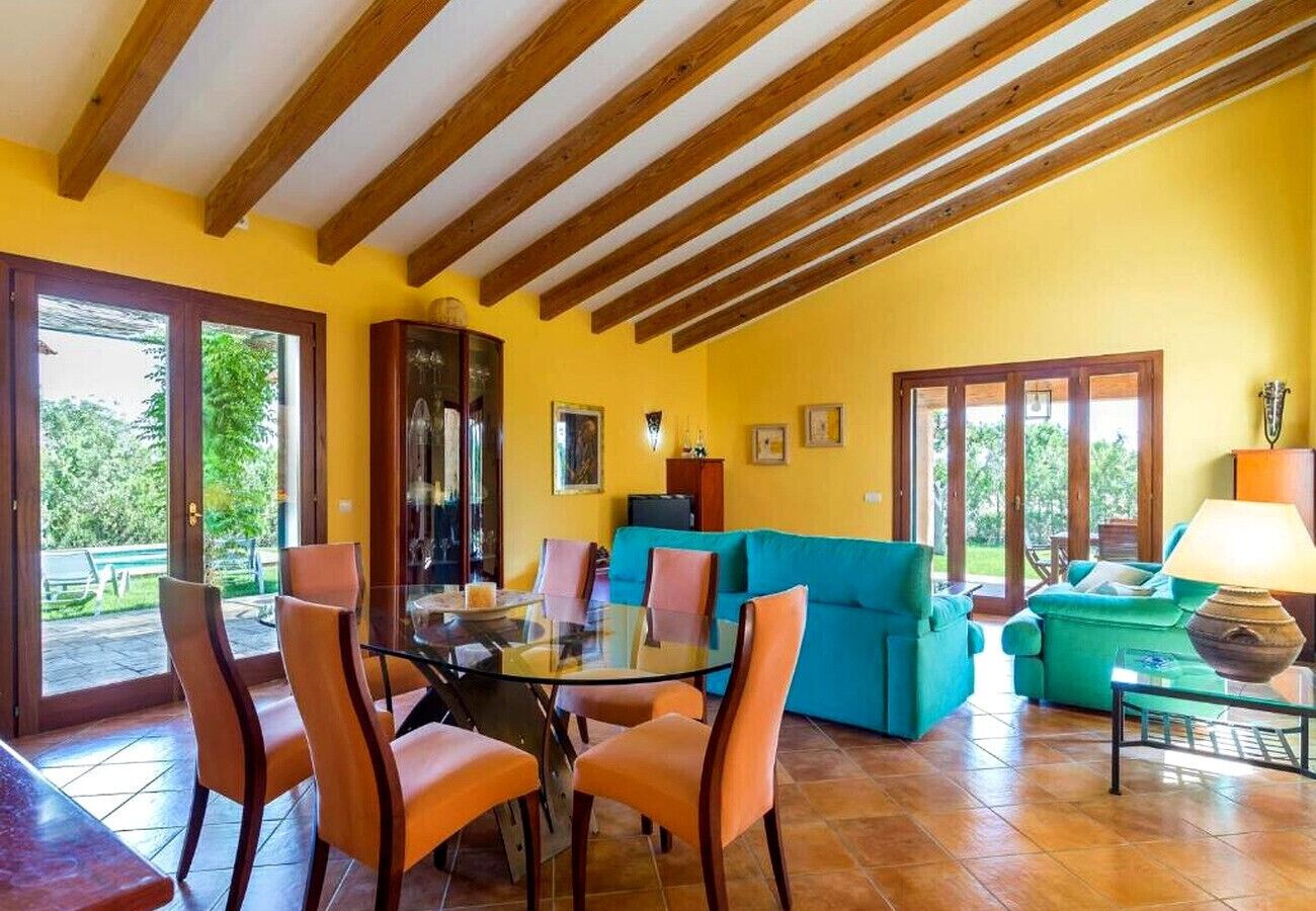 Una habitación con una mesa de comedor, sillas, un sofá y una lámpara.