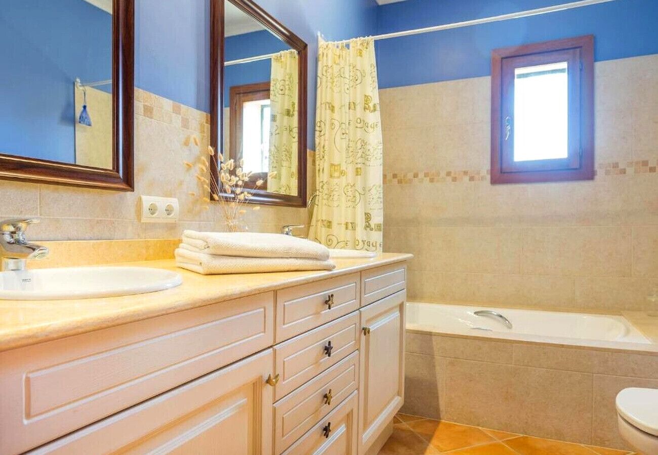 Un baño con lavabo, espejo, tocador y bañera.