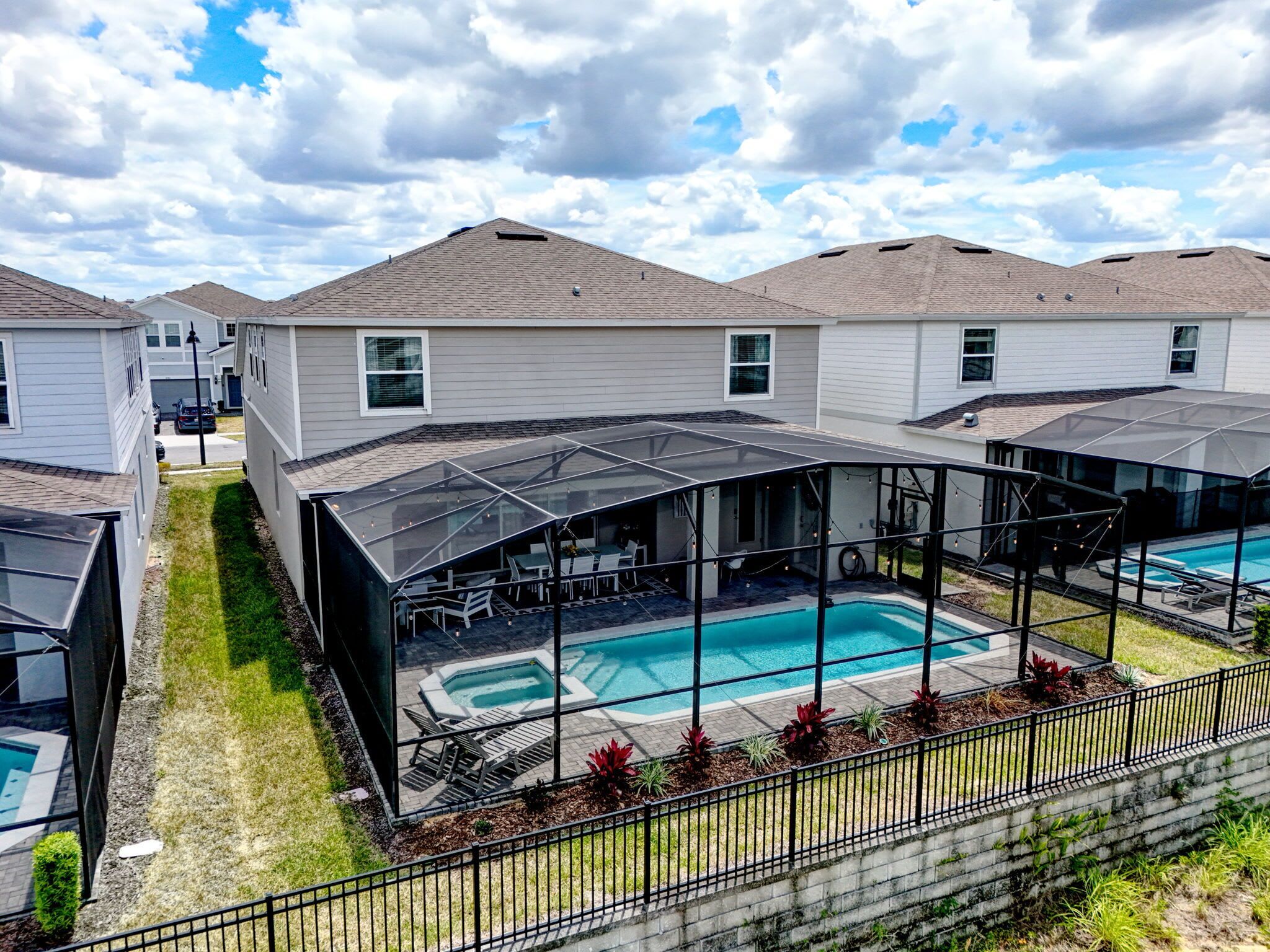 Un quartier résidentiel comprenant plusieurs maisons, une piscine et un patio couvert.